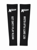 A pair of black arm warmers with white printed text and logos, displayed flat against a white background. The left sleeve features the KLEAN logo at the top and the phrase 'GET DIRTY PLAY KLEAN' printed vertically.